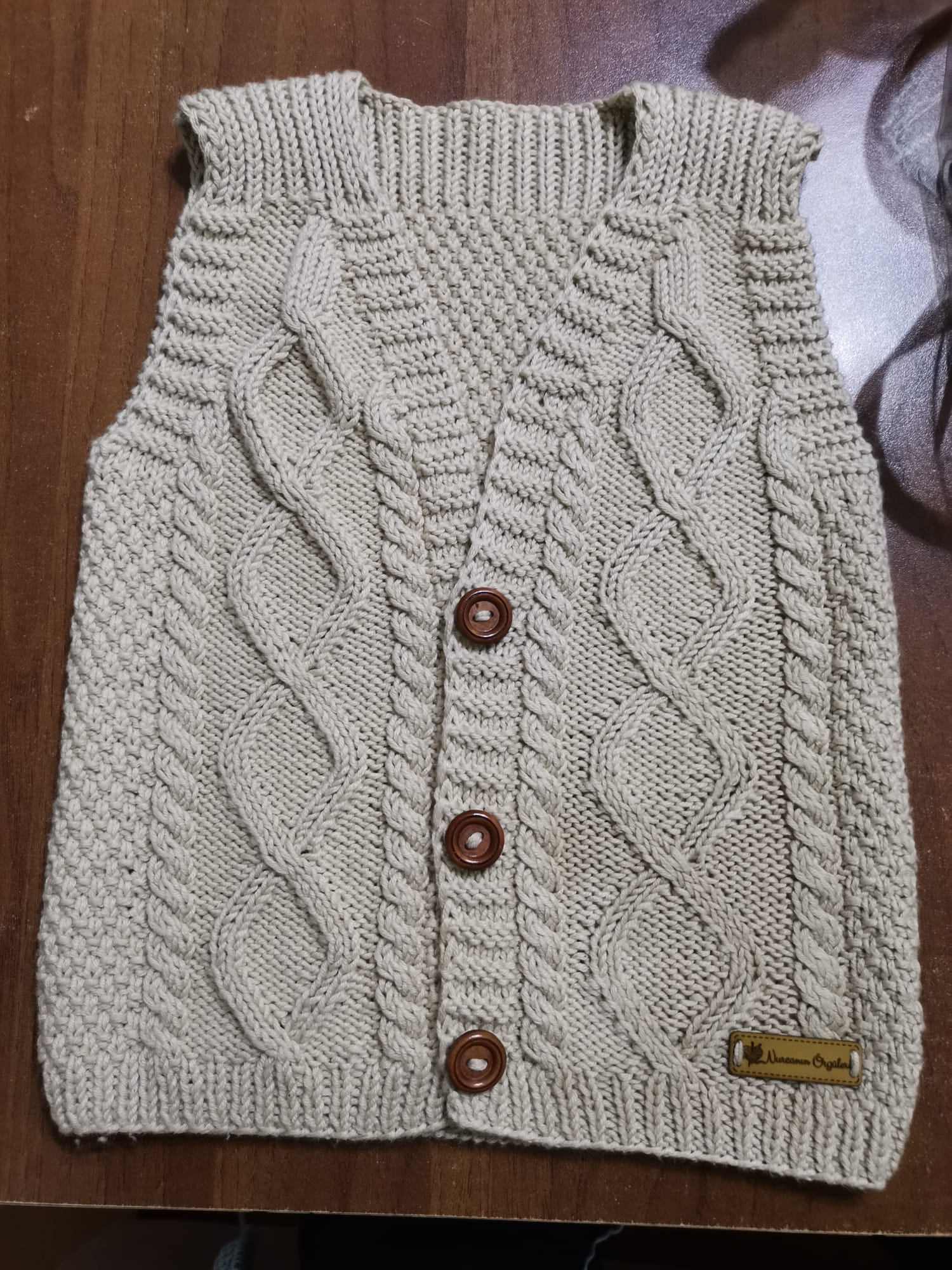 Krem renk burgu desenli düğmeli bebek yeleği ahşap düğme